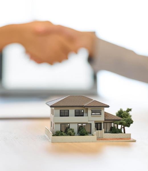 A man and a woman shaking hands during a real estate contract